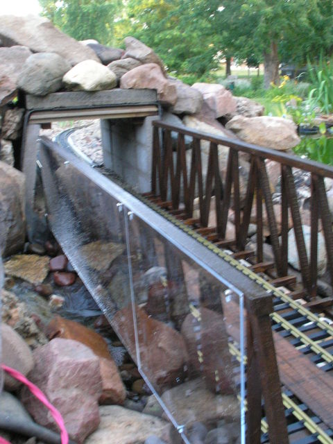 [Plexiglass on upstream side keeps spatters from water falls off rails]